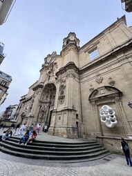 Vorschaubild In der Altstadt finden sich viele Kirchen. Hier die große Basílica de Santa Maria del Coro mit der sehr eigenartigen weißen Skulptur „Armonia del Sonido“.